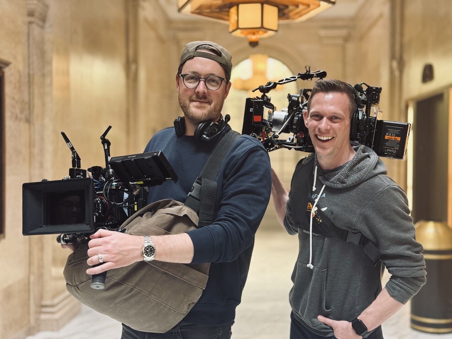 Two men holding RED cameras on set