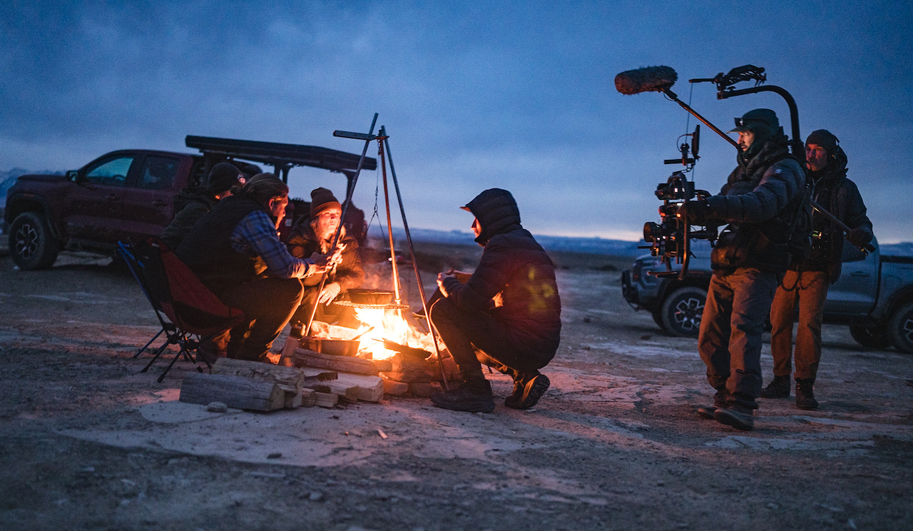 around campfire, RED camera operator and sound engineer recording the scene