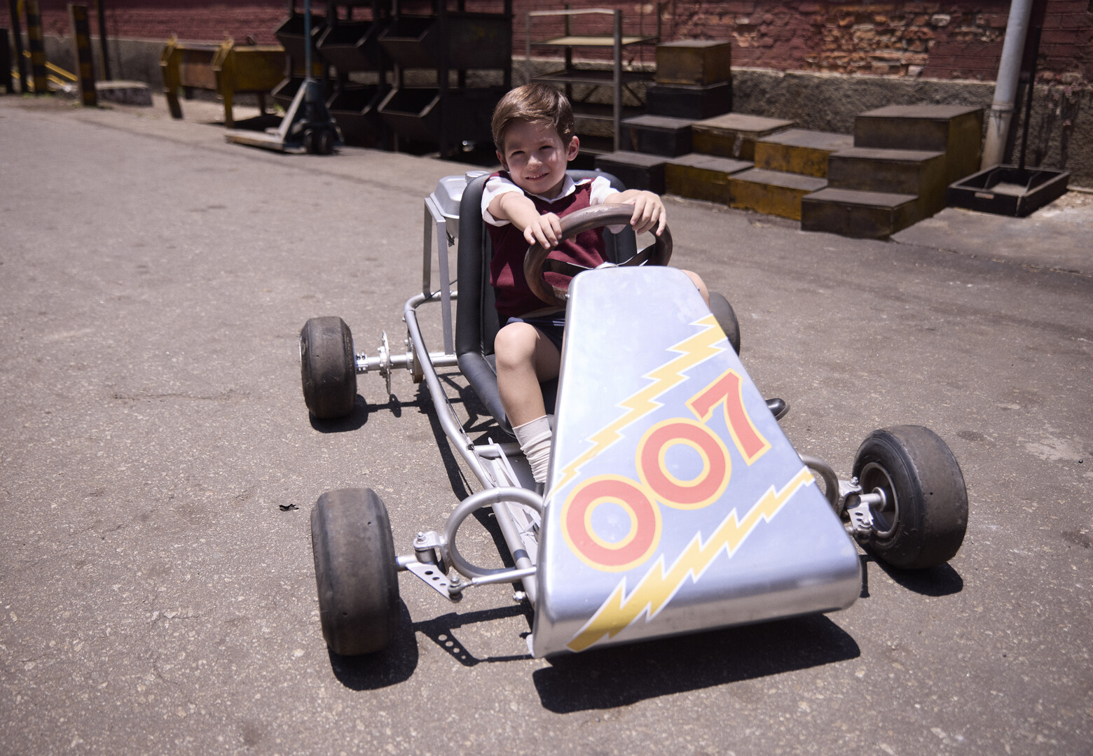 a boy in a go-cart facing the camera