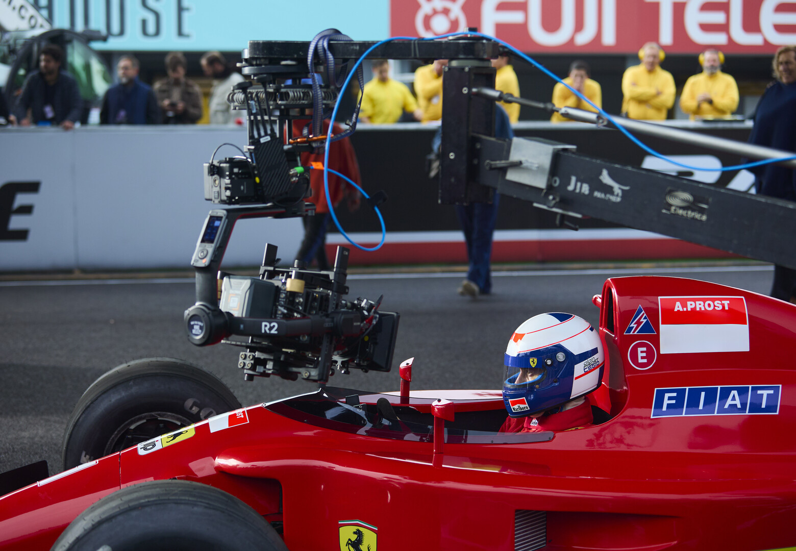 side view of a formula 1 car with a camera crane pointed at it