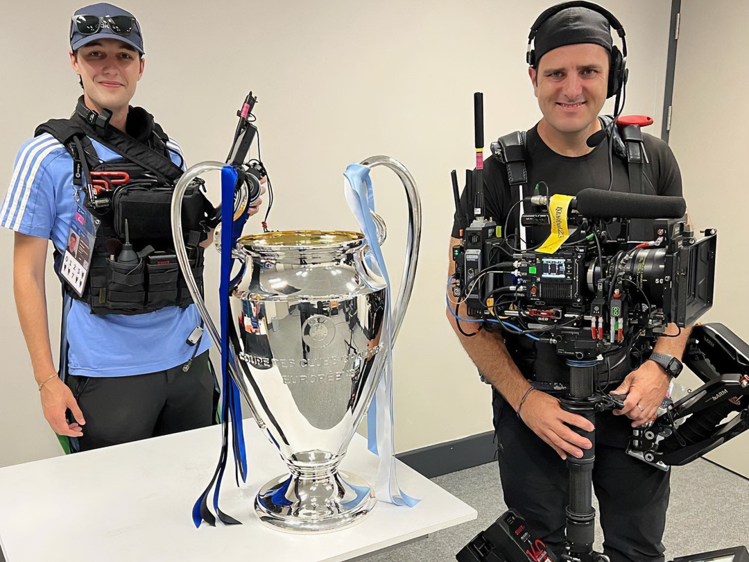 Manu standing next to trophy
