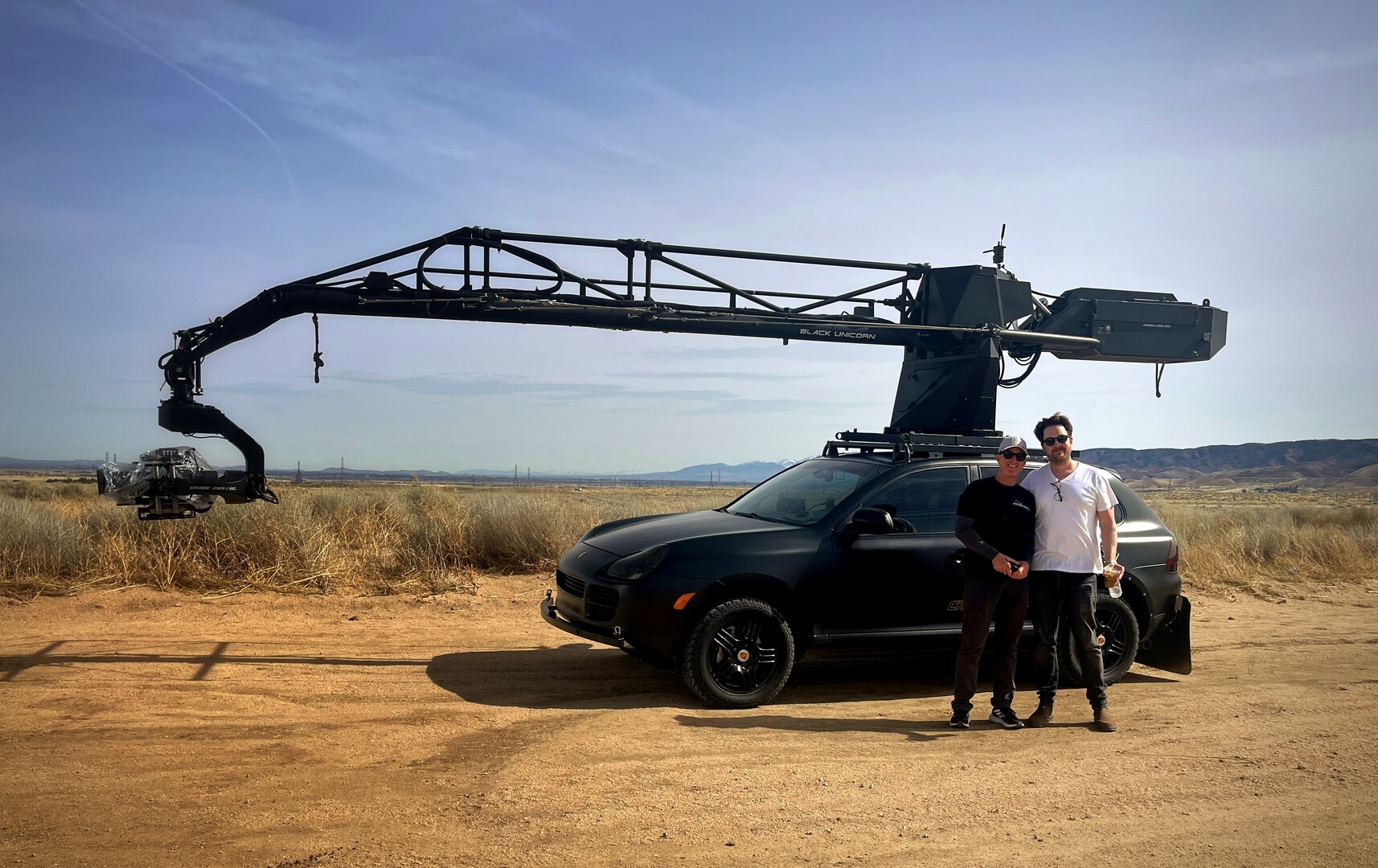 Two men standing in front of a car mounted camera crane