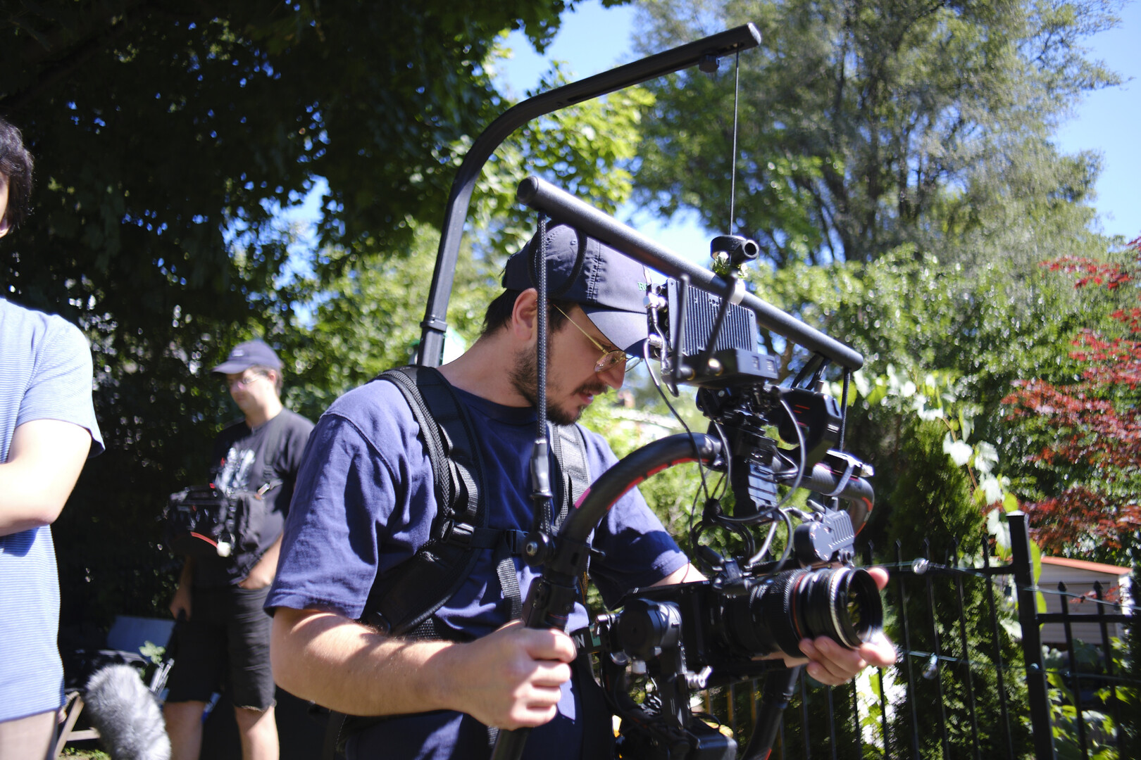 cameraman holding a steadycam rig in a park