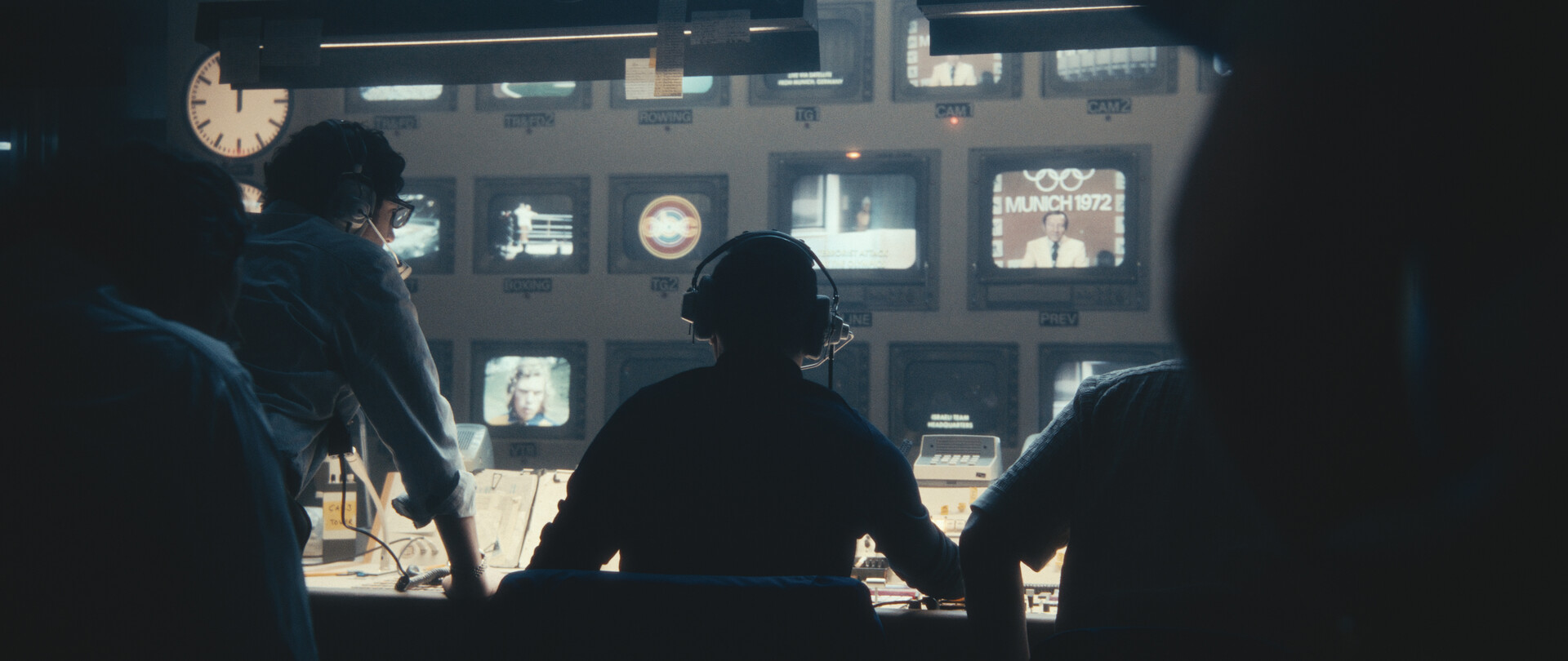 a group of people in a control room seen from behind