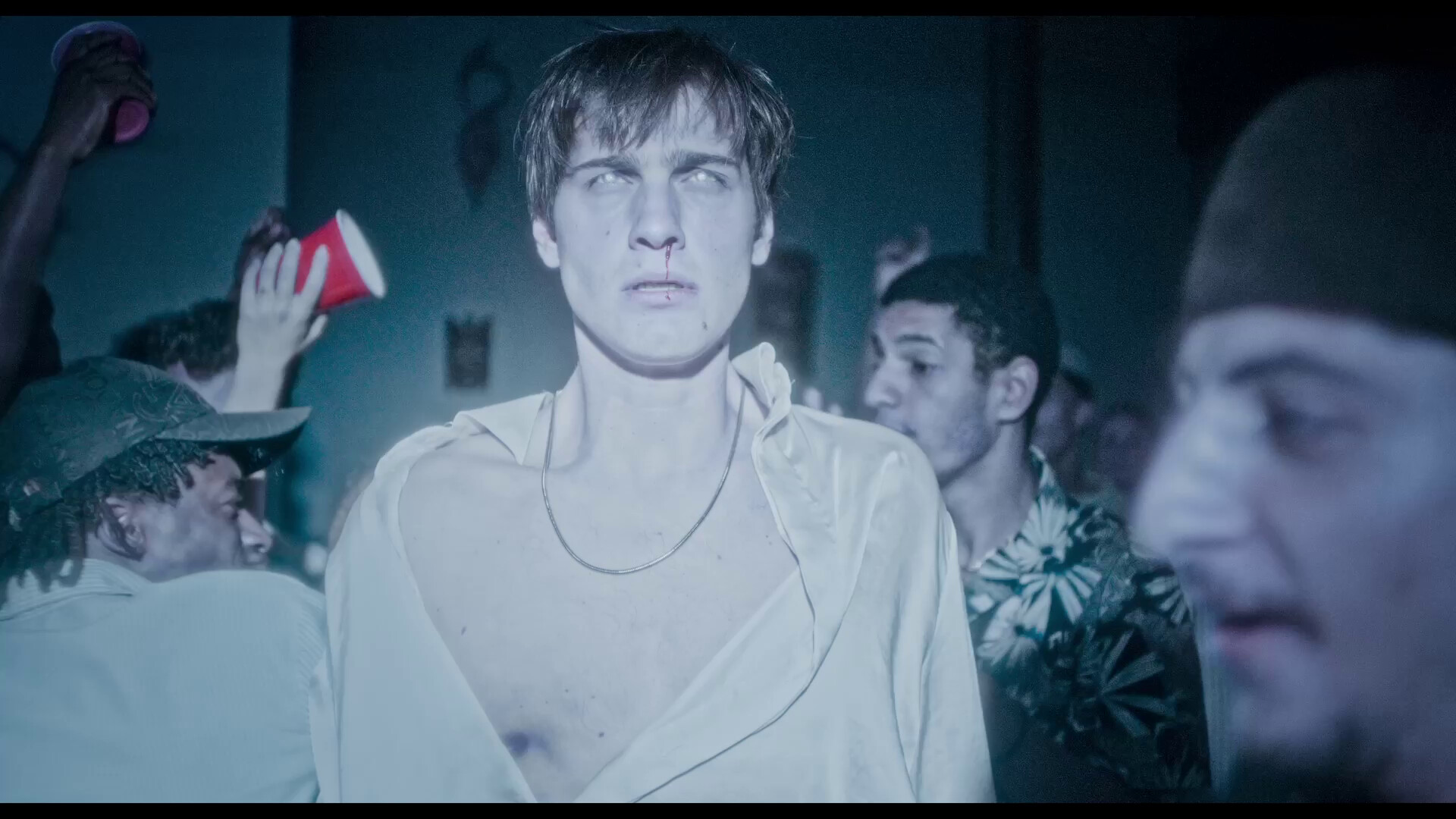 A man walks through a party in a zombie daze