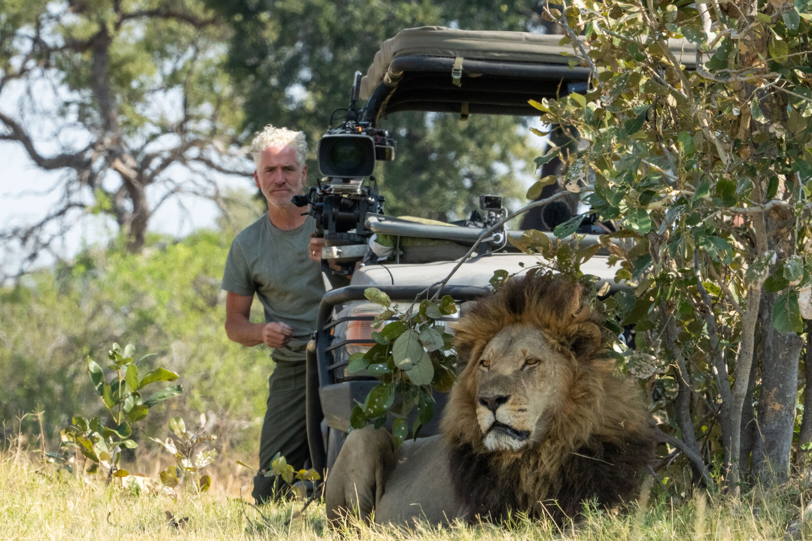 Gordon Buchman with camera and lion in foreground