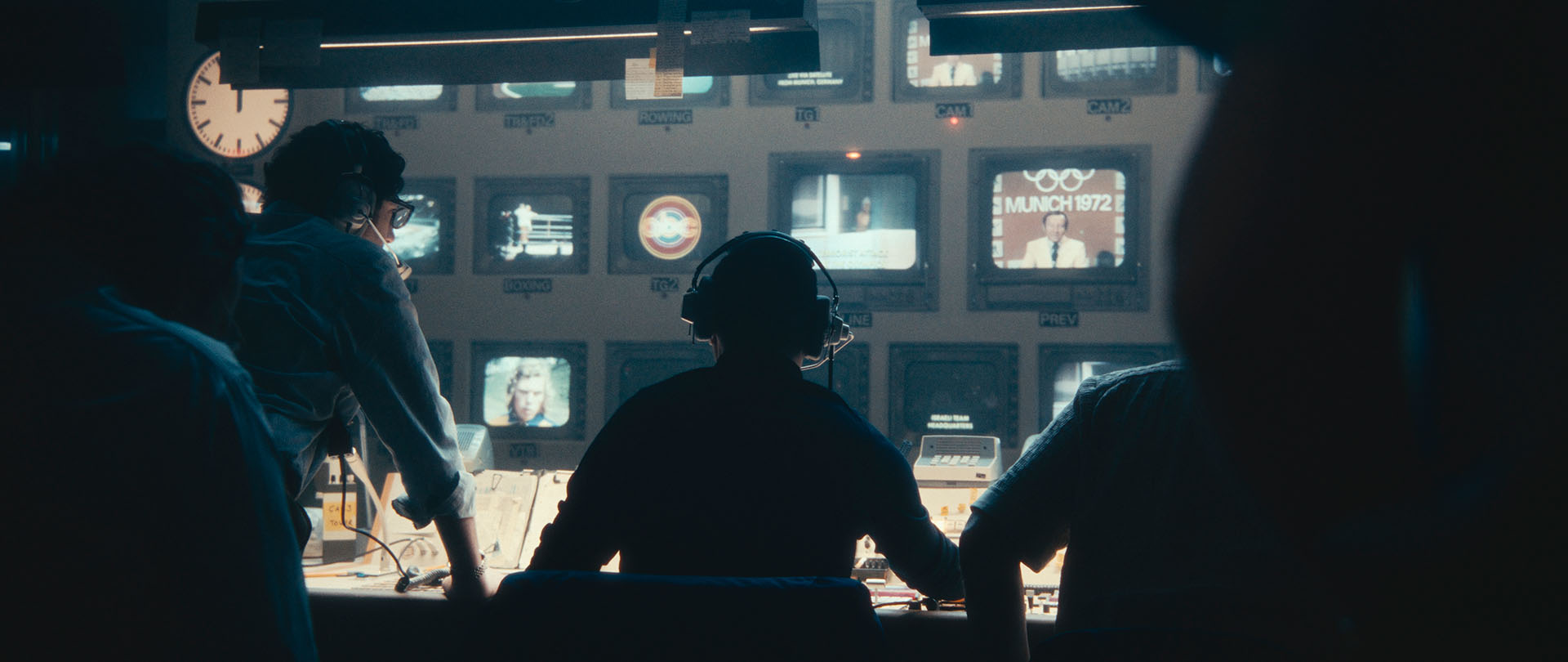 people facing screens in a production control room